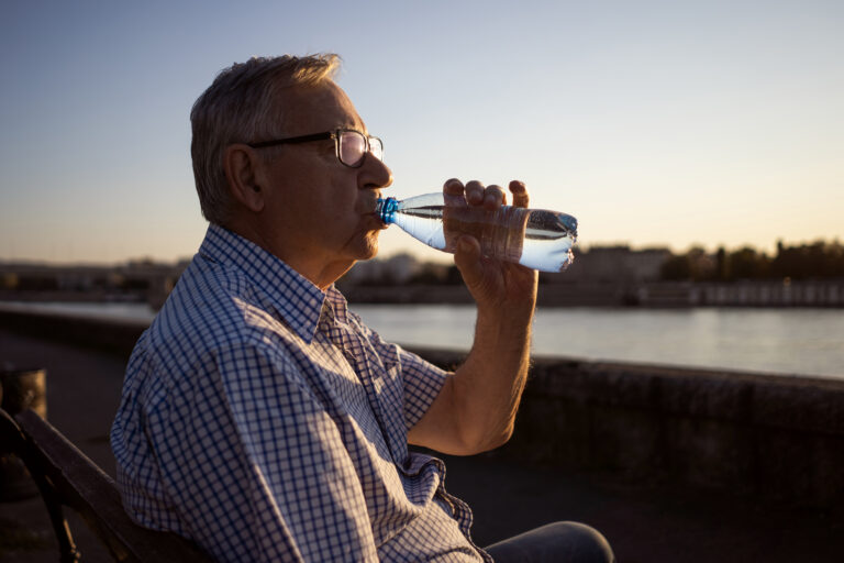 senior man staying hydrated outdoors at sunset 2026 03 20 02 00 26 utc